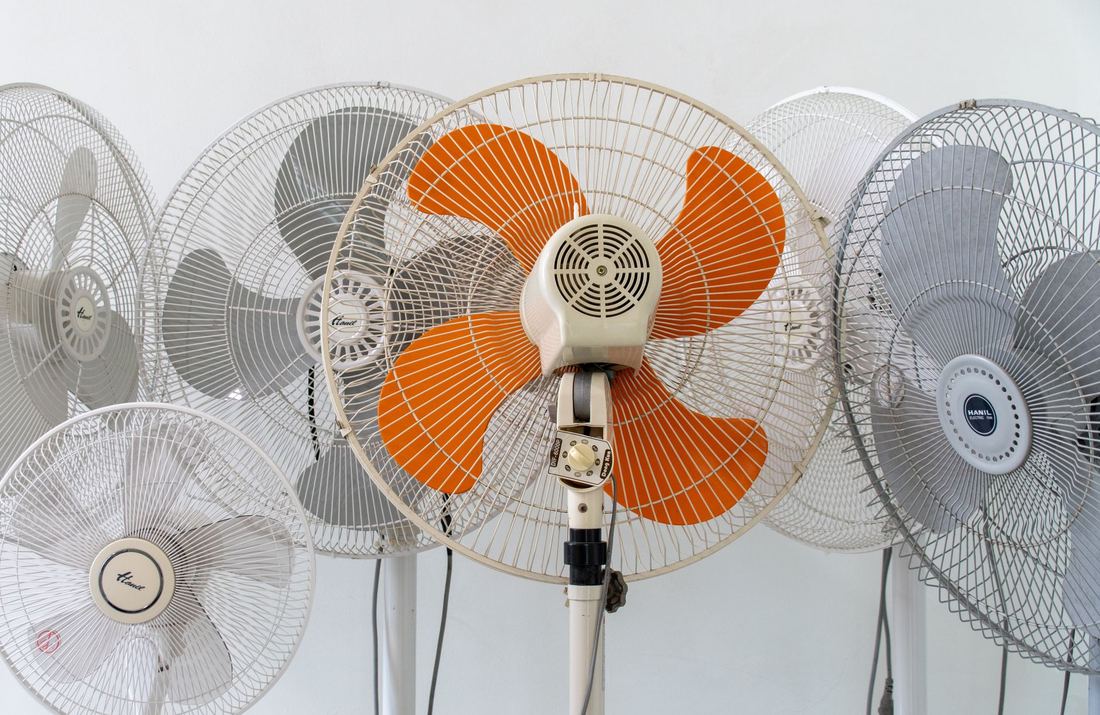 Ventiladores de pie con aspas naranjas y blancas